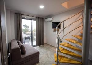 - un salon avec un escalier et un canapé dans l'établissement Artemida Suites, à Chaniotis