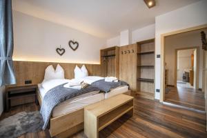 a bedroom with a large bed and wooden floors at Apartments Stua da Carlo in Ortisei