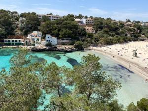 an aerial view of a beach with people in the water at Hostal Palmaria in Cala Santanyi