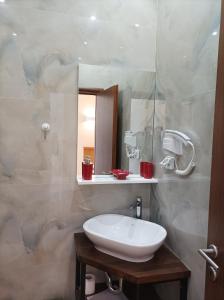 a bathroom with a white sink and a mirror at sofia's cozy rooms in Himare