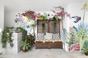 ファロにあるLe Jardin Secret de Faro Guesthouseの壁に植物を置いたベンチ付きの部屋