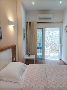 a bedroom with a bed and a door to a patio at sofia's cozy rooms in Himare