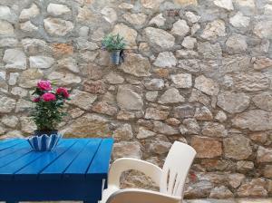 a blue table with a vase of flowers and two chairs at sofia's cozy rooms in Himare