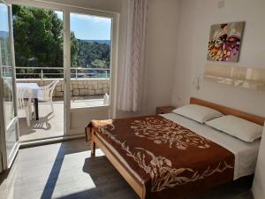 a bedroom with a bed and a view of a balcony at Apartment Portofino in Primošten