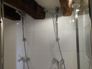 eine Dusche mit zwei Armaturen im Bad in der Unterkunft l'Ancienne Ecole de Rocamadour dans le Lot in Rocamadour