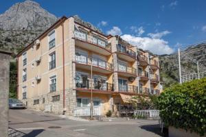 a large building with balconies and a mountain in the background at ENA Apartment in Kotor