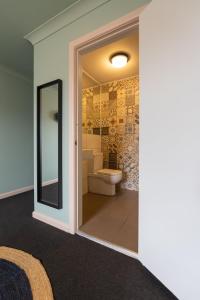 a bathroom with a toilet and a mirror at Roamer St Kilda - formerly Selina St Kilda Melbourne in Melbourne