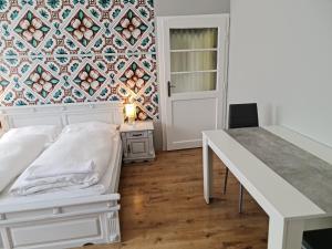 1 dormitorio con cama, mesa y pared en Hürrem Apartman en Eger