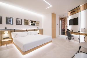 a bedroom with a white bed and a desk at Puerta Serranos by MYR Hotels in Valencia