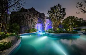 una piscina en el complejo Disneyland por la noche en Grande Centre Point Space Pattaya, en Norte de Pattaya