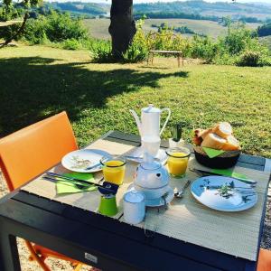a table with a tea set on top of it at Aux Coteaux d'Aussac in L Honor De Cos
