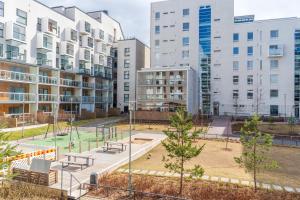 a playground in a park in front of buildings at Iso aurinkoinen parveke ja hyvät yhteydet in Helsinki