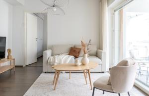 een woonkamer met een bank en een tafel bij Iso aurinkoinen parveke ja hyvät yhteydet in Helsinki