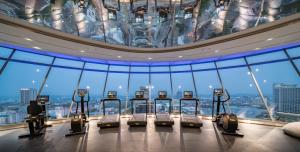a gym with a bunch of machines in a building at Grande Centre Point Space Pattaya in North Pattaya