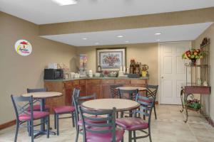 a restaurant with tables and chairs and a kitchen at Super 8 by Wyndham Booneville in Booneville