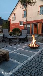 a fire pit in a patio with two benches at Bosman Pokoje Gościnne in Mielenko