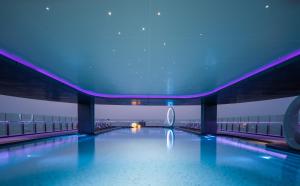 a swimming pool in a building with blue lights at Grande Centre Point Space Pattaya in North Pattaya +83 photos
