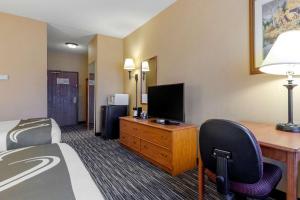 a hotel room with a bed, desk and television at Quality Inn & Suites Wellington – Fort Collins in Wellington