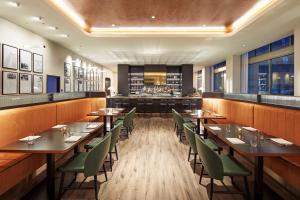 a restaurant with wooden tables and green chairs at Hyatt Centric Sacramento Downtown in Sacramento