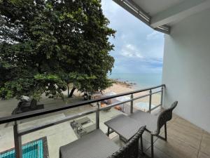 balcón con mesa y sillas y la playa en Prasarnsook Villa Beach Resort, en Sichon