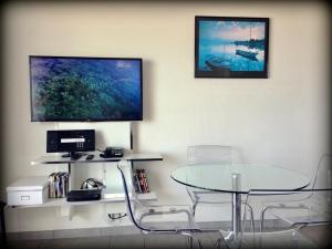 a table and chairs in a room with a tv at ''Luigi'' BALCON SUR LA MER et le Port de Sète in Sète