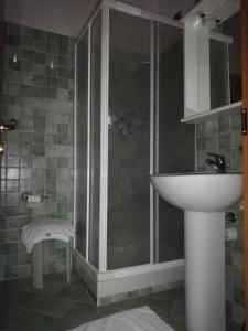 łazienka z przeszkloną kabiną prysznicową i umywalką w obiekcie Locanda Cà de Rusitta w mieście Vezzi Portio