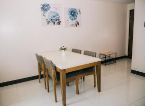 una mesa de comedor con sillas y un jarrón de flores. en EGO's CONDO-Mactan NewTown Cebu-1BR en Isla de Mactán