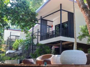 una casa con balcones y sillas de mimbre frente a ella en Prasarnsook Villa Beach Resort, en Sichon