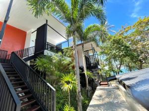 a house with stairs and palm trees in front of it at Prasarnsook Villa Beach Resort in Sichon