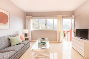 a living room with a couch and a tv at Apartamentos Barranco del Infierno in Adeje