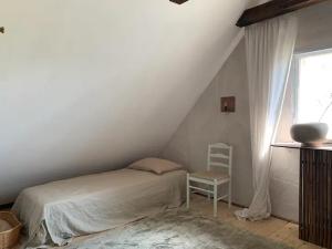 ein Schlafzimmer mit einem Bett und einem Stuhl neben einem Fenster in der Unterkunft Österlen loft in Tomelilla