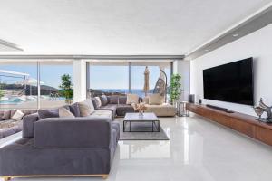 a living room with a large couch and a flat screen tv at Luxury Villa for 8 with 20m large Infinity Pool in Kalkan in Kaş