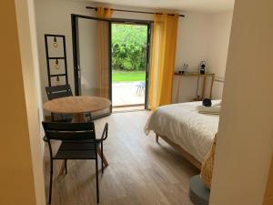 a bedroom with a bed and a table and a door at La Villa Hossegor in Hossegor +23 photos