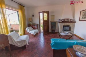 ein Wohnzimmer mit einem blauen Sofa und einem Kamin in der Unterkunft Appartamento Maria Teresa in Porto Santo Stefano