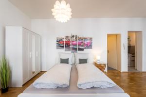 biała sypialnia z 2 łóżkami i żyrandolem w obiekcie Große Altstadtwohnung in TOP Lage Zentrum w Dreźnie