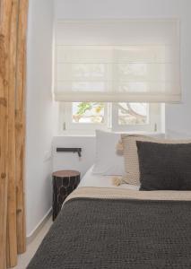 a bedroom with a bed with a window at Karai, The House Project in Astypalaia Town