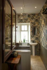 baño con lavabo y aseo y ventana en The Presbytery, Forres en Forres