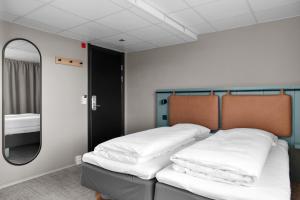 two beds in a room with a mirror at Comfort Hotel Børsparken in Oslo