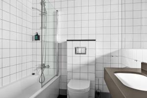 a bathroom with a toilet and a sink and a shower at Comfort Hotel Børsparken in Oslo