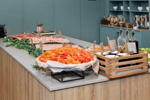 a buffet with carrots on a counter with bottles of wine at Comfort Hotel Børsparken in Oslo
