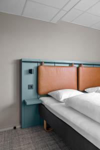 a bed with two pillows and a head board at Comfort Hotel Børsparken in Oslo