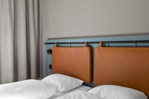 two beds with white pillows sitting next to a window at Comfort Hotel Børsparken in Oslo
