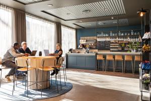 a group of people sitting at a table in a restaurant at Comfort Hotel Børsparken in Oslo