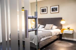 a bedroom with a large bed with two lamps at Flandres Appart' Hotel - Schepers in Lille
