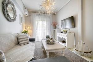 ein Wohnzimmer mit einem Sofa und einem Tisch in der Unterkunft Luxury Apartments Zeas Piraeus in Piräus