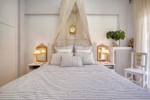 a white bedroom with a large bed with a canopy at Luxury Apartment Zeas Piraeus in Piraeus