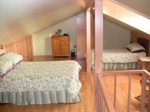 a bedroom with two beds and a loft at La Source Enchantée in Baie-Saint-Paul
