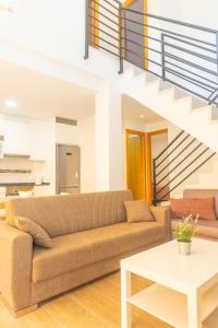 uma sala de estar com um sofá e uma escada em Duplex Sereno 6 - Piscina, Garaje, Jardín y Playa em Los Caños de Meca