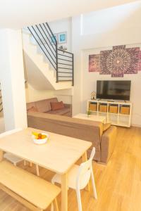 uma sala de estar com uma mesa e um sofá em Duplex Sereno 6 - Piscina, Garaje, Jardín y Playa em Los Caños de Meca