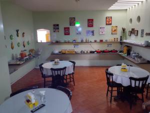 a restaurant with two tables and chairs in a room at Pousada Aconchego in Juazeiro do Norte